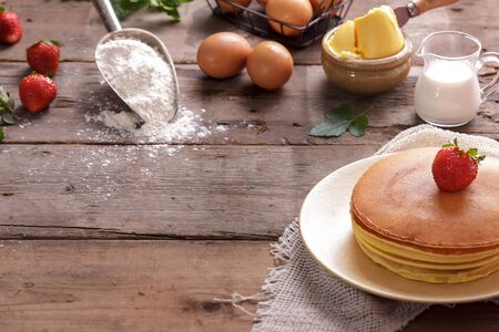 portrait of delicious homemade pancake with ingredients on wooden table with spaceの写真素材