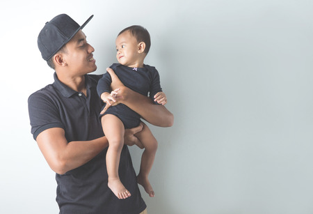 A portrait of a Young Asian father holding his adorable baby on white backgroundの写真素材