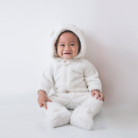 little baby girl sitting on the floor isolated on a white background