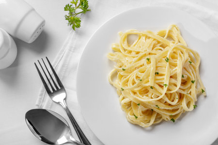 full top view portrait of italian tagliatelle carbonara sauce on plain white plate