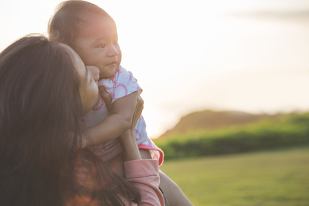 Beautiful Mother And Baby outdoors. Nature. Beauty Mum and her Child playing in Park togetherの写真素材