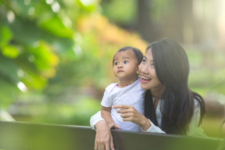 portrait of Beauty Mother and her Child playing in Park together