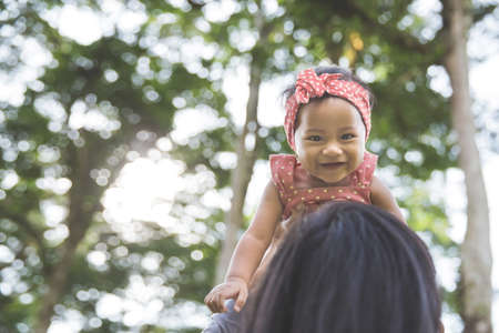Portrait of happy loving mother and her baby outdoorsの写真素材