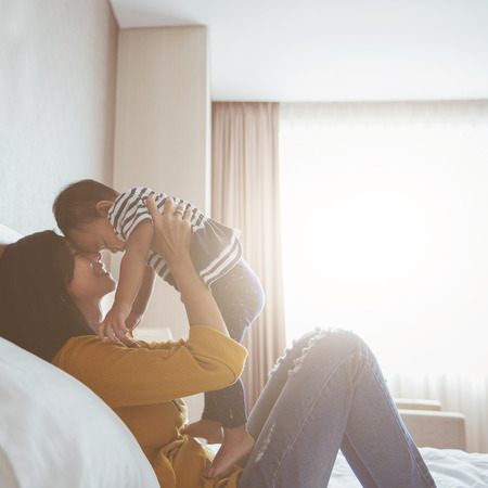 Portrait of mother and baby playing and smiling at home.