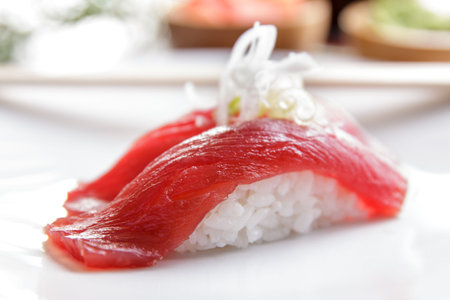 portrait of japanese food nigiri tuna sushi on white plate with chopsticksの写真素材