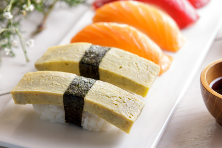 top view portrait of japanese cuisines nigiri sushi set on white plate served with wasabi, soy sauce, and chopsticksの写真素材