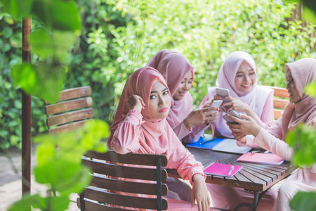 group of young girl using their own smartphone and ignoring her friend