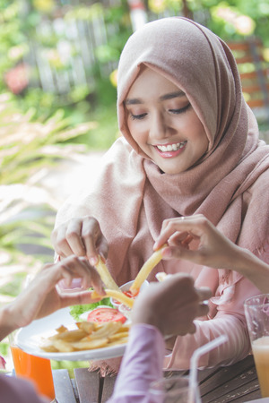 portrait of young best friend sharing lunch in restaurantの写真素材