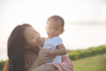 portrait of Beauty Mother and her Child playing in Park togetherの写真素材