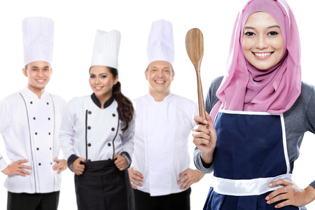 portrait of group of chef isolated over white background. muslim woman at the frontの写真素材