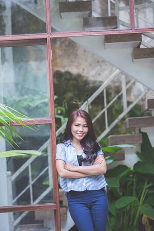 Portrait of a attractive confident woman smiling against windowの写真素材