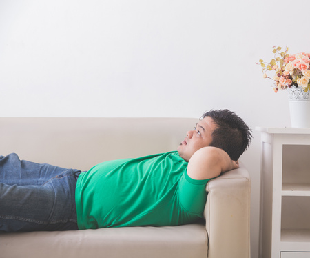 portrait of lazy Fat obese man sleeping on the couchの写真素材