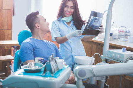 female Dentist talking showing patient of his x ray radiograph