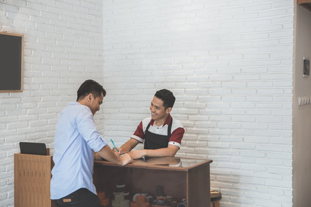 portrait of a worker taking order from customer at the shopの写真素材