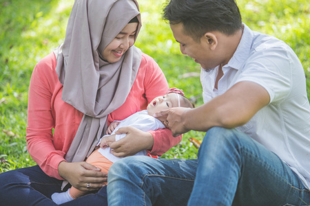 portrait of Beauty Mother and father with their newborn baby in the parkの写真素材