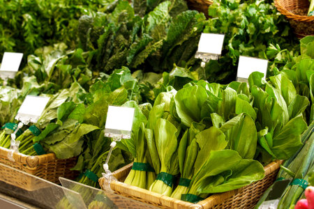 portrait of a group of fresh pak choi and kailan in basket at supermarket display