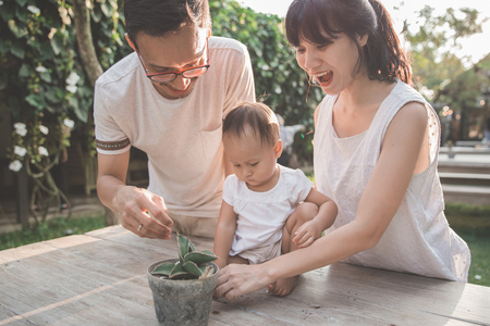 proud parents with their kid playing outside in the gardenの写真素材