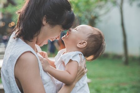 portrait of happy mother and her baby have fun in the gardenの写真素材
