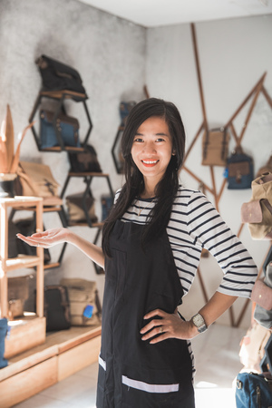 young happy shop owner welcoming customerの写真素材