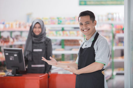 happy young male shopkeeper welcoming customerの写真素材
