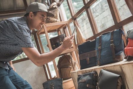 business owner taking picture of his bag product to sell it onlineの写真素材