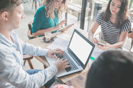 portrait of businessman busy on his laptop during team meeting at cafeの写真素材