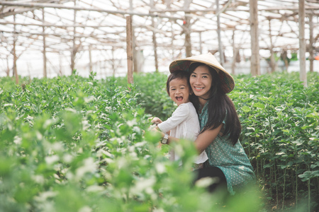 portrait of mother and her daughter farming in the farm togetherの写真素材