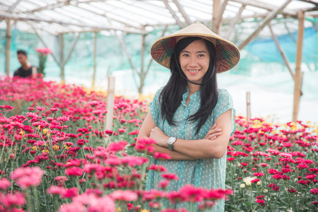 portrait of a young asian woman harvesting chamomile flowersの写真素材