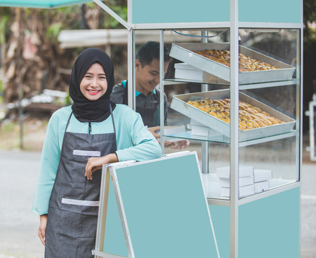 asian muslim woman small business owner and her food stall. halal product conceptの写真素材