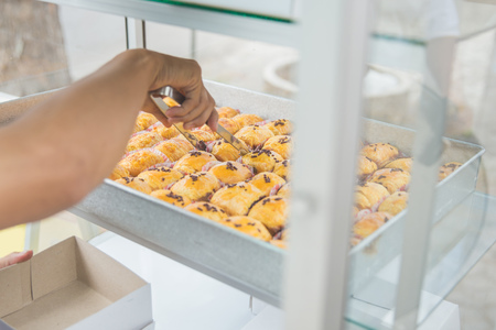 portrait of man taking a cake at his food stall. street food conceptの写真素材