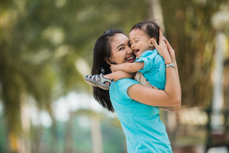 excited mother and son enjoying together outdoorの写真素材