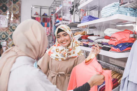 two happy female muslim best friend at fashion storeの写真素材