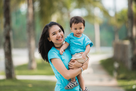 happy asian mother with her son enjoying their time together outdoorの写真素材