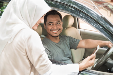 portrait of asian woman showing direction to the driver using GPS in her mobile phone