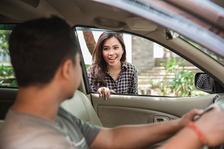 female taxi customer. smiling while talking to her driverの写真素材