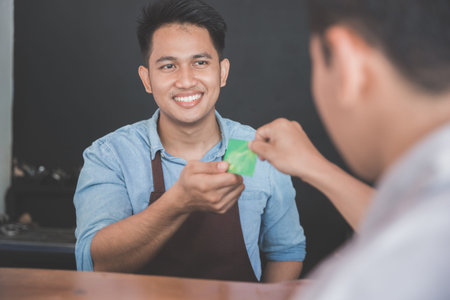 customer paying his bills using credit card, cashless payment