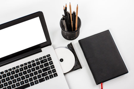 working space with laptop, disc, notebook and stationary
