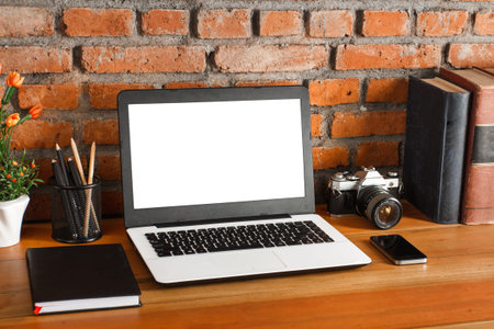 working space on wooden table and brick wall background