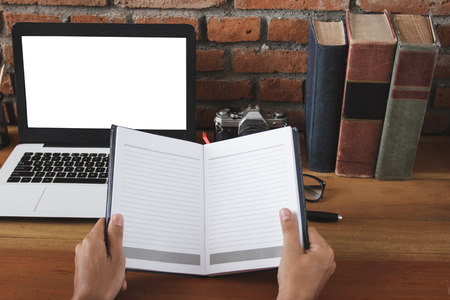 hands holding blank notebook at working spaceの写真素材