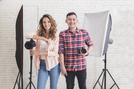 two young photographer in studio with lighting at the background