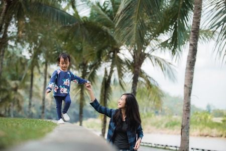 happy little girl with her mom walkingの写真素材