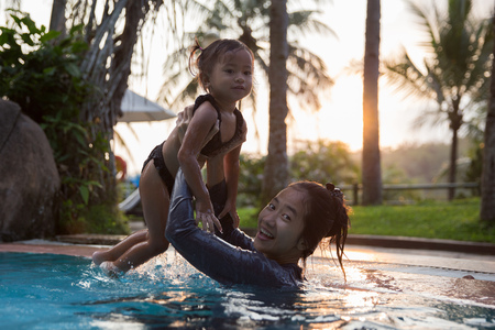mother and daughter swim in the poolの写真素材