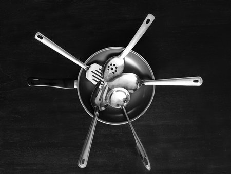 top view portrait of set of metal kitchen utensils and frying pan