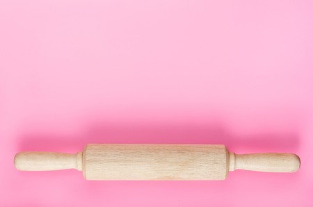 portrait of wooden rolling pin on pink background on pink backgrouond with copy spaceの写真素材