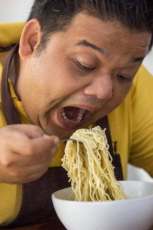 Young fat man eatingの写真素材