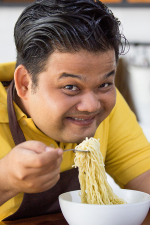 Young fat man eatingの写真素材