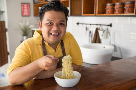 Young fat man eatingの写真素材