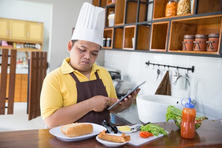 happy young man cooking his mealの写真素材