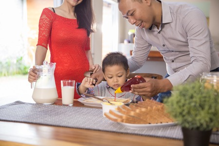 happy asian family having breakfast togetherの写真素材