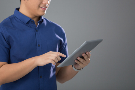 Asian Young Man in Casual using tabletの写真素材
